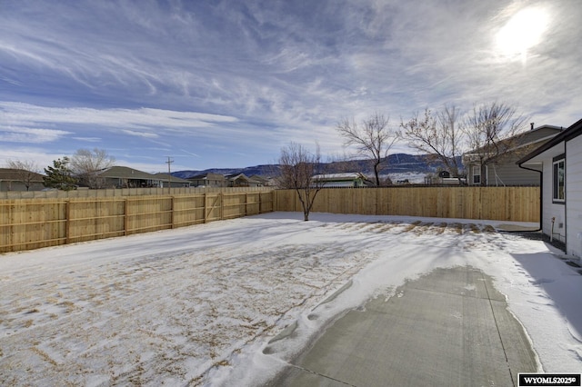 snowy yard with a fenced backyard and a residential view