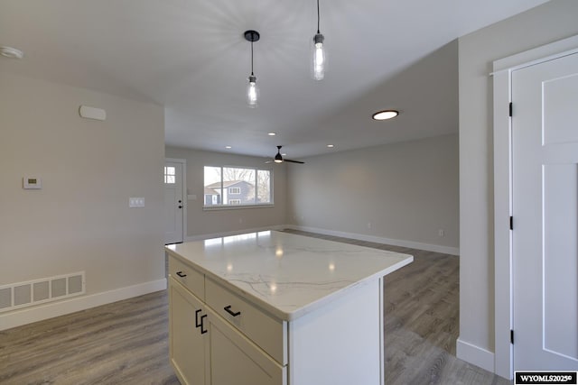 kitchen featuring ceiling fan, baseboards, open floor plan, light wood-type flooring, and recessed lighting