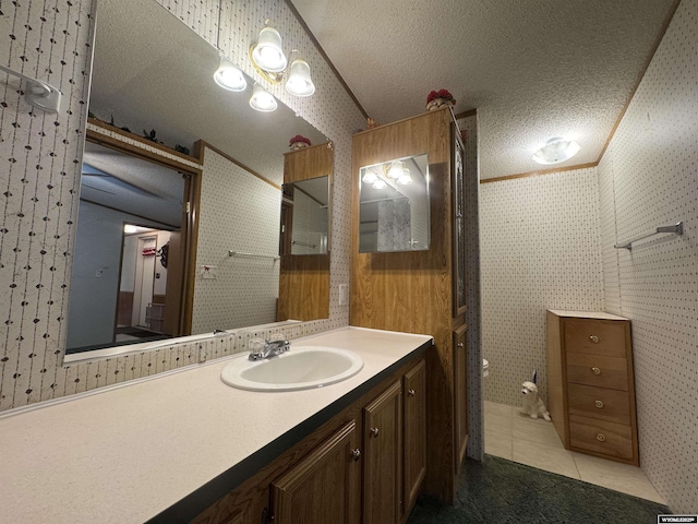 1414 Eileen St, Riverton, WY 82501 - bathroom featuring tile patterned flooring, wallpapered walls, vanity, and a textured ceiling