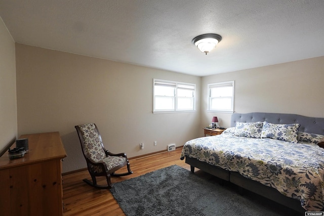 bedroom with light wood finished floors and baseboards