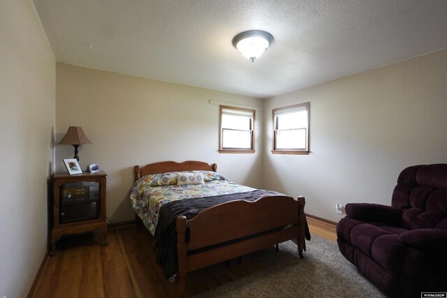 bedroom featuring wood finished floors and baseboards