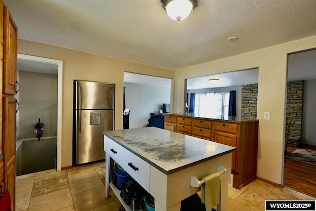 kitchen with freestanding refrigerator, brown cabinets, and a center island