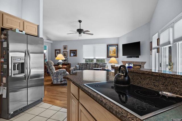 kitchen with stainless steel fridge with ice dispenser, open floor plan, light brown cabinets, black electric stovetop, and plenty of natural light