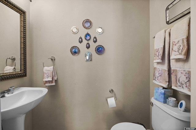 half bath featuring toilet and a sink
