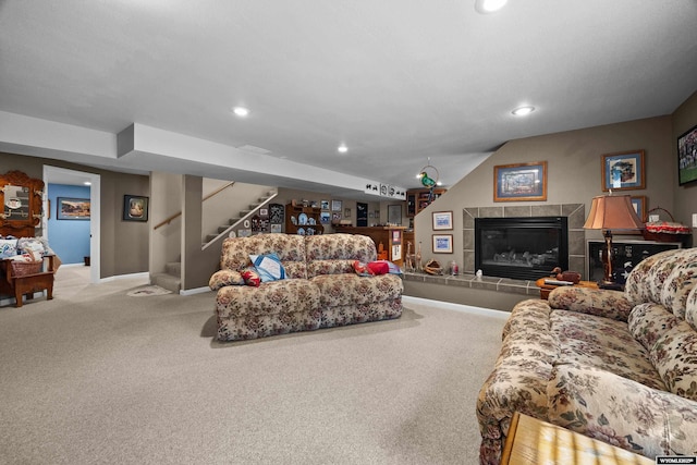 carpeted living room featuring recessed lighting, stairway, baseboards, a tiled fireplace, and lofted ceiling