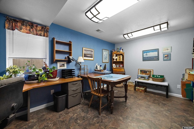 office space featuring stone finish flooring and baseboards