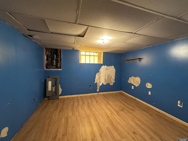 219 W Franklin St, Morrill, NE 69358 - below grade area featuring wood finished floors, a paneled ceiling, and baseboards