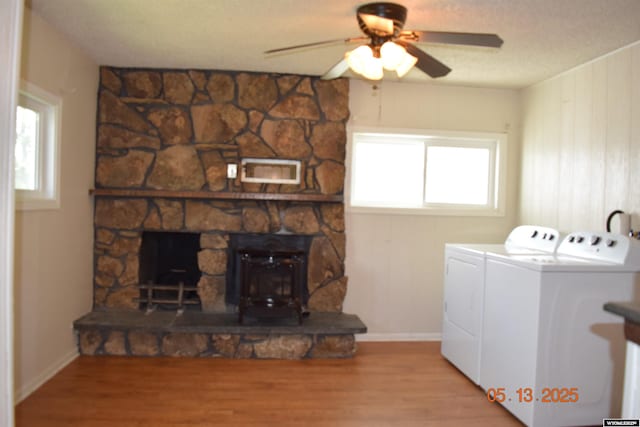 laundry area featuring washing machine and dryer, wood finished floors, ceiling fan, and baseboards