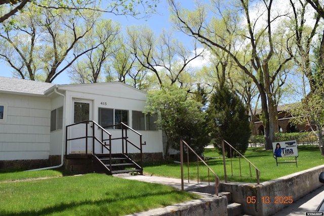 view of front facade with a front lawn and a shingled roof