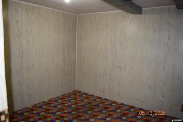 unfurnished room featuring wood walls and tile patterned floors