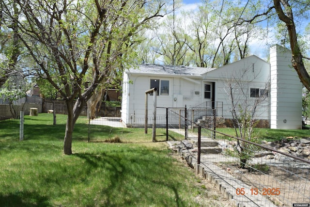 rear view of house with a chimney, a gate, and a shingled roof
