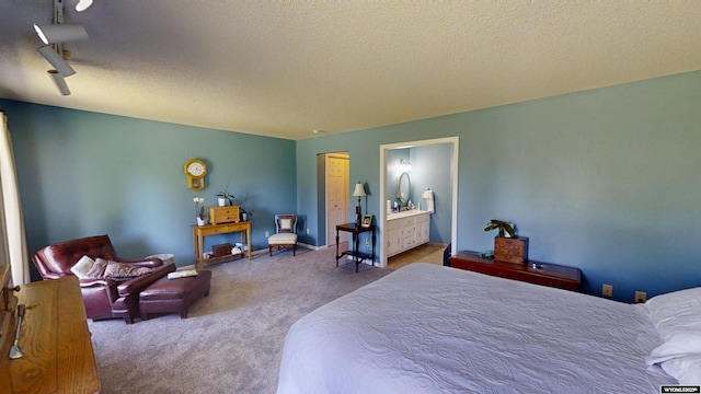 bedroom featuring carpet flooring, a textured ceiling, ensuite bath, and baseboards