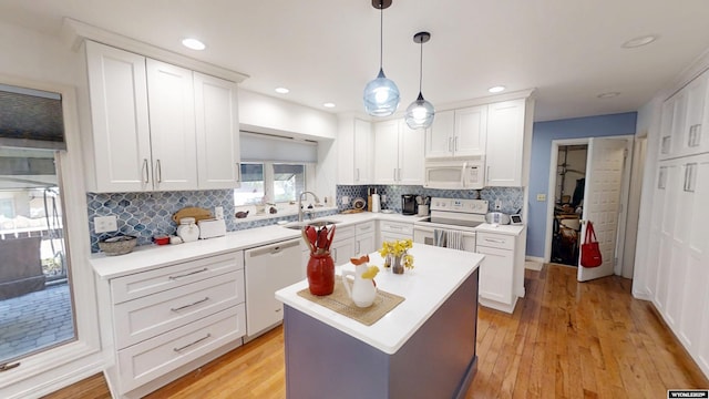 kitchen featuring white appliances, a sink, white cabinetry, tasteful backsplash, and recessed lighting