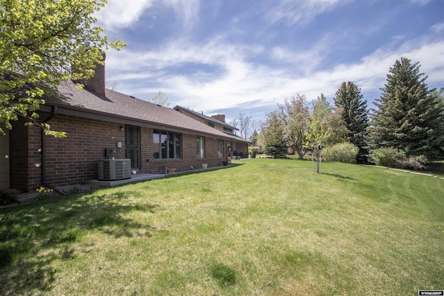 view of green lawn featuring cooling unit