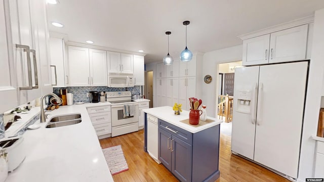 kitchen featuring white appliances, a sink, light countertops, white cabinetry, and recessed lighting