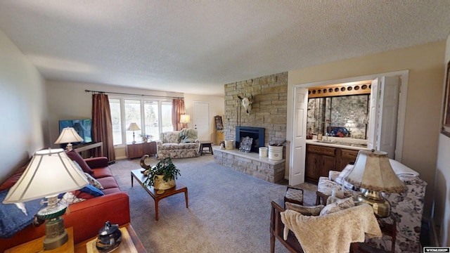 living area with a textured ceiling, a fireplace, and carpet flooring