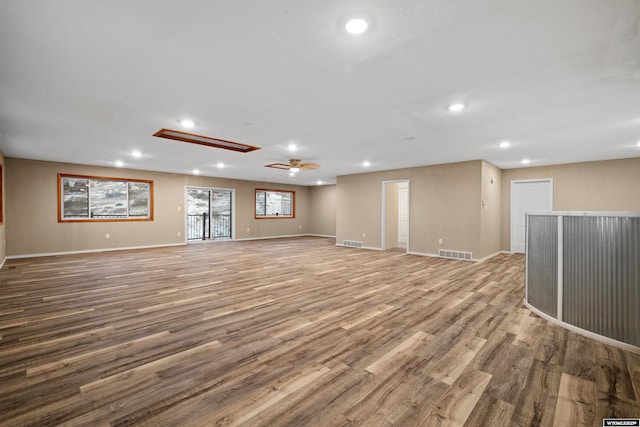 unfurnished living room with recessed lighting, wood finished floors, baseboards, ceiling fan, and a dry bar