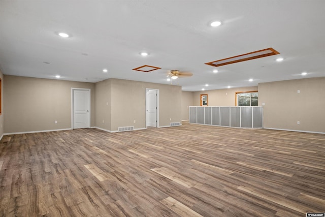 unfurnished room featuring wood finished floors, baseboards, recessed lighting, and attic access