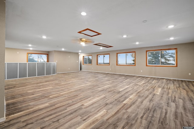 spare room featuring recessed lighting, wood finished floors, and baseboards