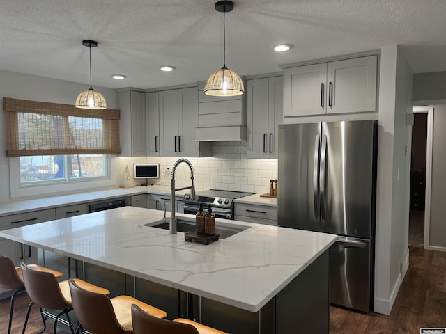 2715 Colorado Dr, Green River, WY 82935 - kitchen featuring stainless steel appliances, light stone countertops, dark wood-style flooring, decorative backsplash, and a textured ceiling