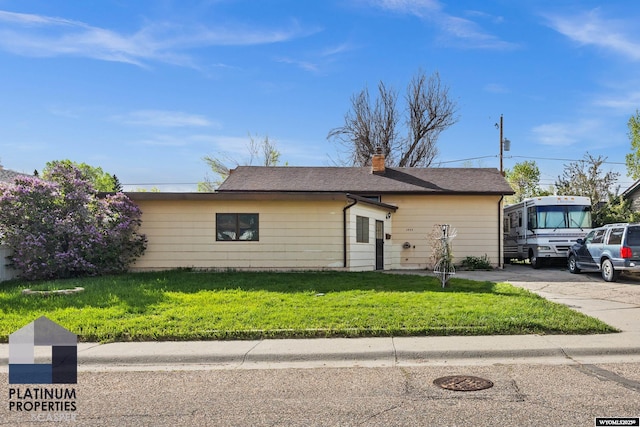 ranch-style home with a front lawn and a chimney