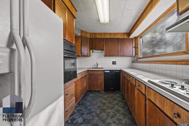 kitchen featuring black appliances, a sink, decorative backsplash, dark colored carpet, and light countertops