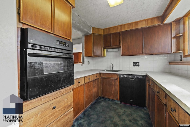 kitchen featuring black appliances, a sink, tasteful backsplash, and dark carpet