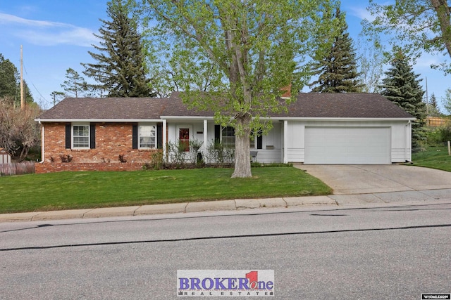 ranch-style house featuring an attached garage, driveway, a front yard, and brick siding