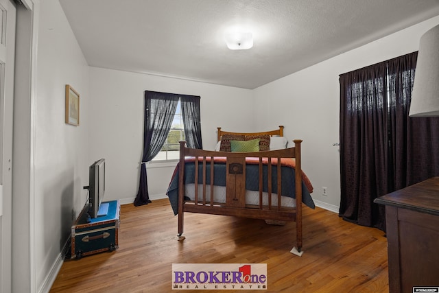 bedroom featuring light wood-style flooring and baseboards