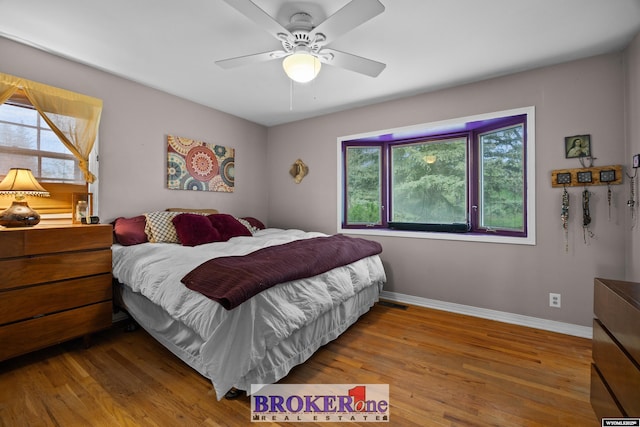 bedroom with wood finished floors, baseboards, and a ceiling fan