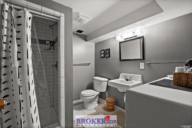 bathroom with a shower stall, toilet, baseboards, and a sink