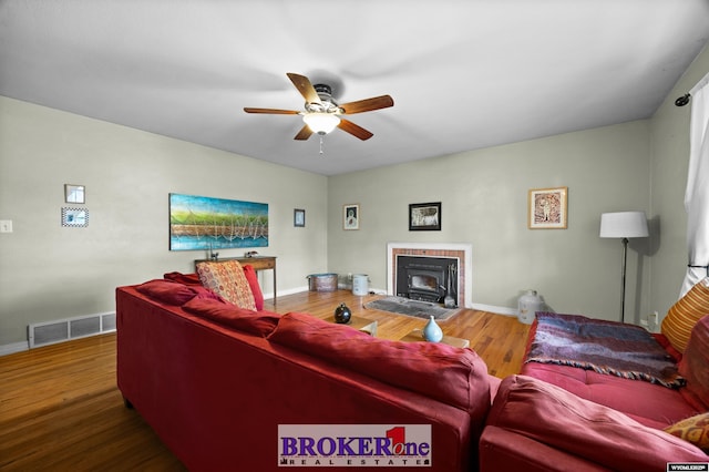 living room featuring ceiling fan, wood finished floors, and baseboards
