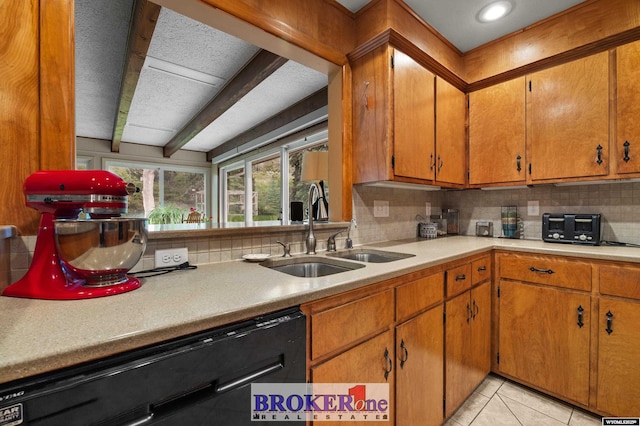 kitchen with dishwasher, a sink, decorative backsplash, light countertops, and light tile patterned floors