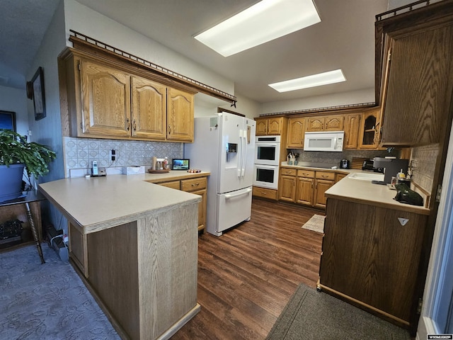 1008 N Rd 11, Worland, WY 82401 - kitchen with white appliances, a peninsula, decorative backsplash, light countertops, and dark wood-style flooring