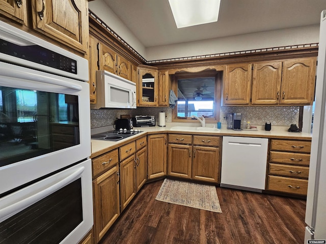 1008 N Rd 11, Worland, WY 82401 - kitchen featuring white appliances, a sink, dark wood finished floors, light countertops, and tasteful backsplash