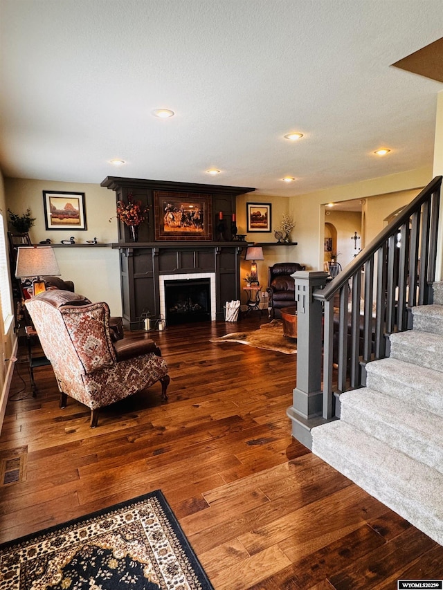 101 Pebble Ln, Torrington, WY 82240 - living area with hardwood / wood-style flooring, a fireplace, stairs, recessed lighting, and arched walkways