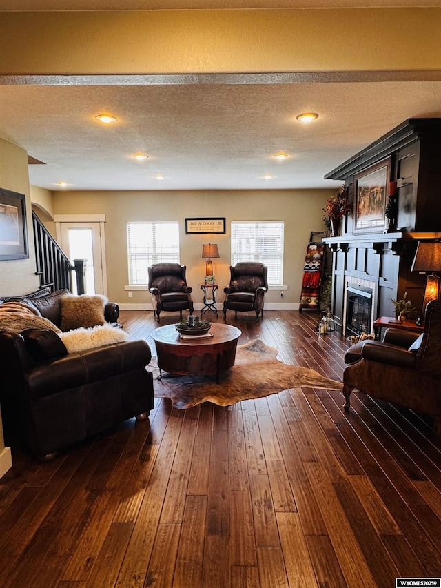 101 Pebble Ln, Torrington, WY 82240 - living area with a glass covered fireplace, dark wood-style floors, stairs, and baseboards