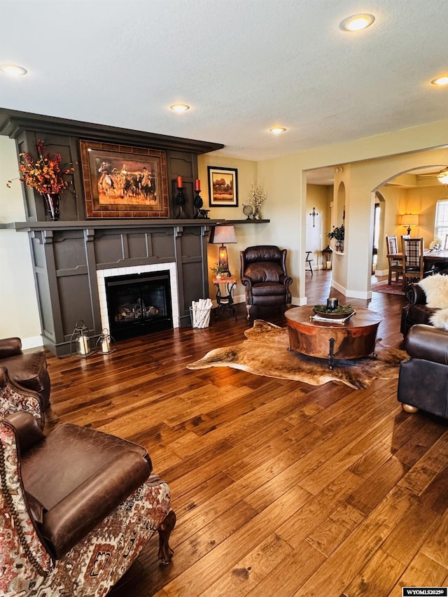 101 Pebble Ln, Torrington, WY 82240 - living room with arched walkways, a fireplace, wood-type flooring, baseboards, and recessed lighting
