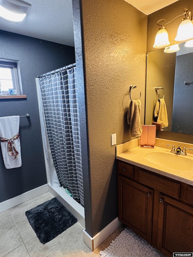 101 Pebble Ln, Torrington, WY 82240 - full bath with a shower with curtain, vanity, a textured wall, and baseboards