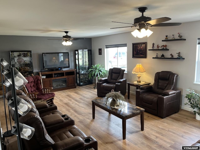 living room with ceiling fan, light wood-style flooring, and baseboards