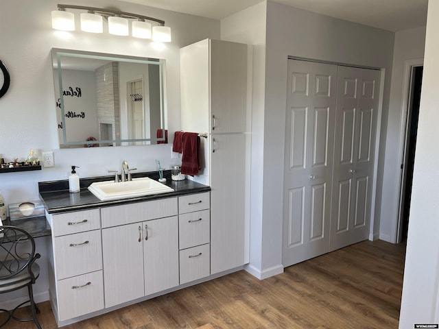 bathroom with wood finished floors, vanity, and baseboards
