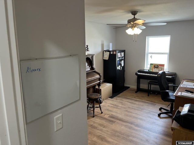 home office with a ceiling fan and light wood finished floors