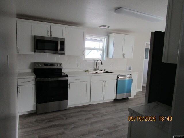 263 N 2nd Street E, St, Green River, WY 82935 - kitchen with stainless steel appliances, a sink, decorative backsplash, light countertops, and white cabinets