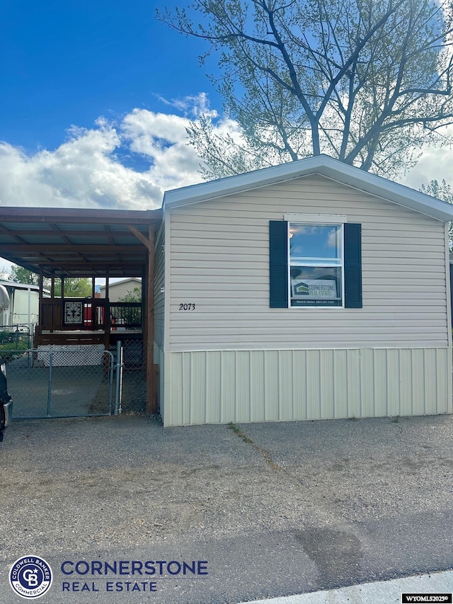 view of side of property featuring an attached carport and driveway