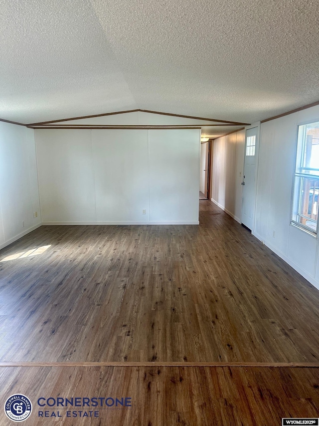 spare room featuring a textured ceiling, dark wood finished floors, and ornamental molding