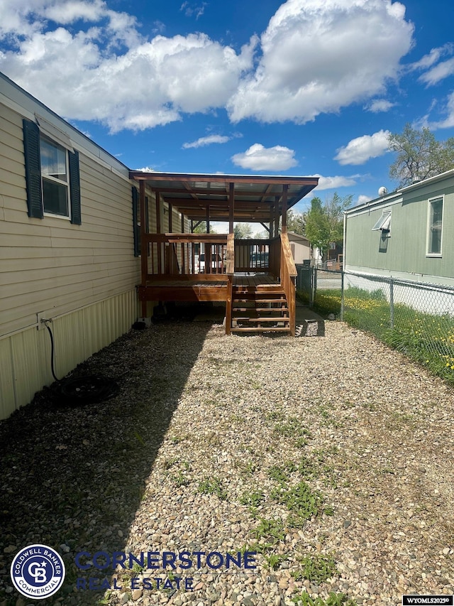 view of yard with fence, a wooden deck, and stairway