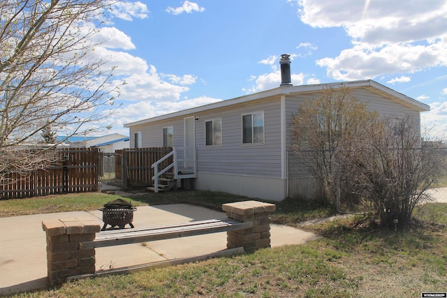 7 N Schmid Dr, La Barge, WY 83123 - rear view of property featuring fence, a fire pit, and a patio area