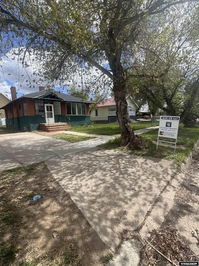 237 4th St, Evanston, WY 82930 - view of front of property featuring concrete driveway and a chimney