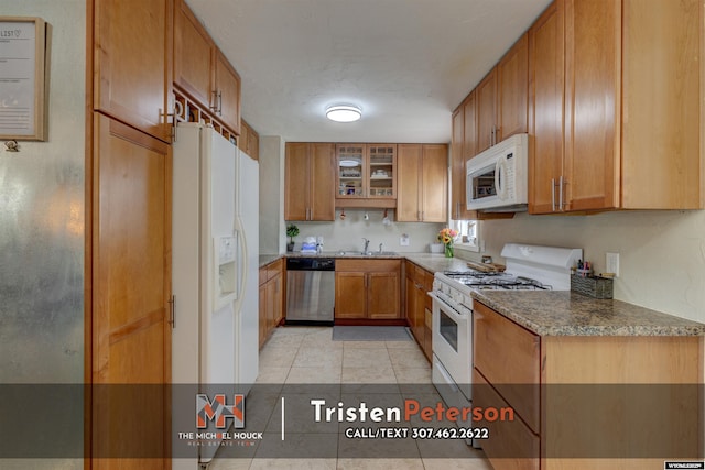 2819 E 6th St, Casper, WY 82609 - kitchen with white appliances, brown cabinets, light tile patterned flooring, glass insert cabinets, and a sink
