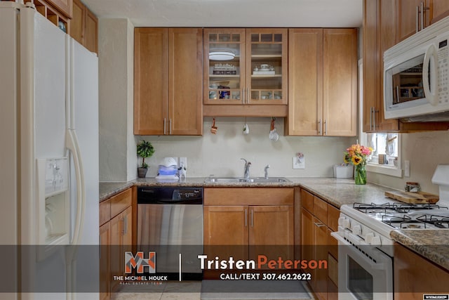 2819 E 6th St, Casper, WY 82609 - kitchen with white appliances, a sink, glass insert cabinets, and brown cabinets